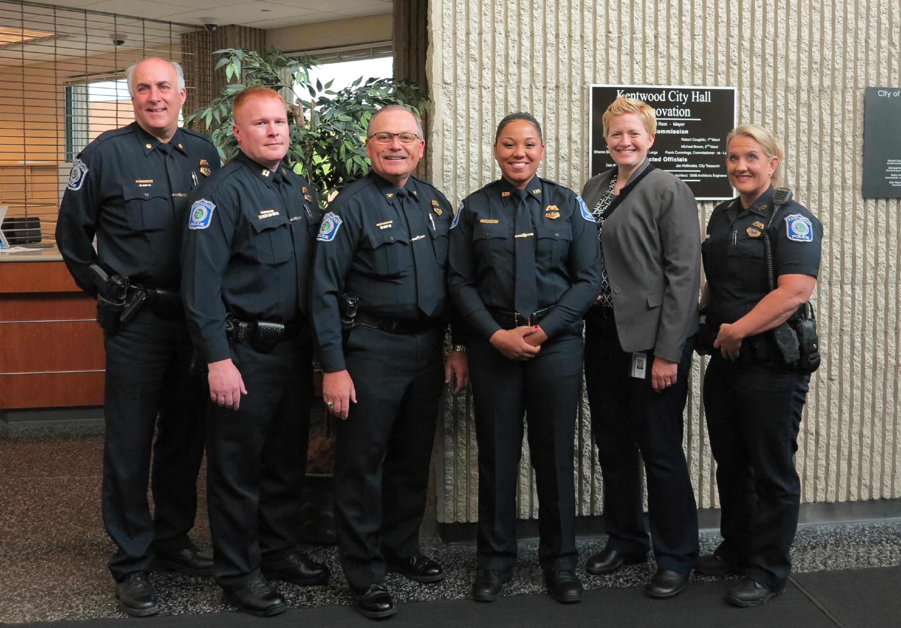 DC Roberts, Capt. Litwin, Chief Hillen, Officer Heard, Captain Morningstar and Officer Clark stand together and smile for a photo following Officer Heard's swearing in.